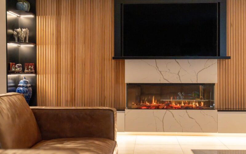 Custom living room feature wall with built-in fireplace, timber slats and backlit joinery